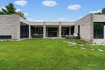 Experience modern luxury with this stunning home featuring a sleek stone facade and expansive glass windows.