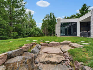 Experience modern luxury in this stunning home featuring a sleek architectural design and expansive windows that seamlessly blend indoor and outdoor living.