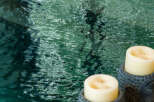 Experience ultimate relaxation with this serene spa-like setting, featuring a tranquil pool and calming Buddha-head candle holders.
