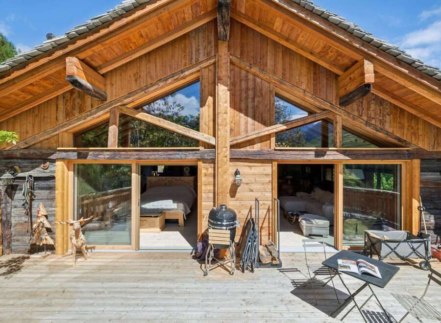 Experience rustic charm in this stunning wooden chalet, featuring expansive glass doors that open onto a spacious deck.