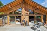 Experience rustic charm in this stunning wooden chalet, featuring expansive glass doors that open onto a spacious deck.