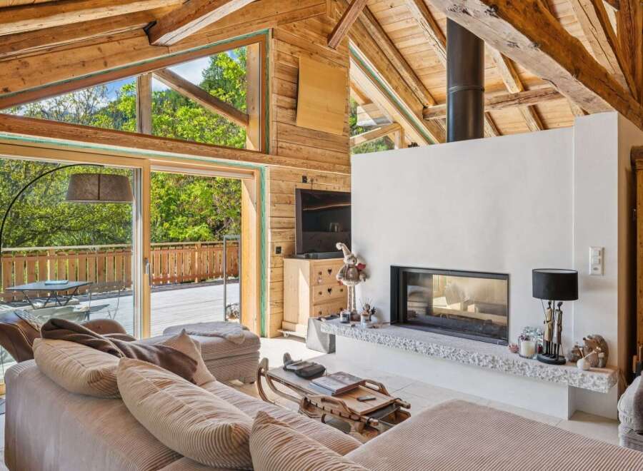 Experience the ultimate alpine retreat in this stunning living room, featuring a modern fireplace and expansive windows that flood the space with natural light.