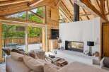 Experience the ultimate alpine retreat in this stunning living room, featuring a modern fireplace and expansive windows that flood the space with natural light.