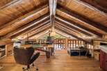 Discover this unique attic workspace, featuring exposed wooden beams and a rustic charm.