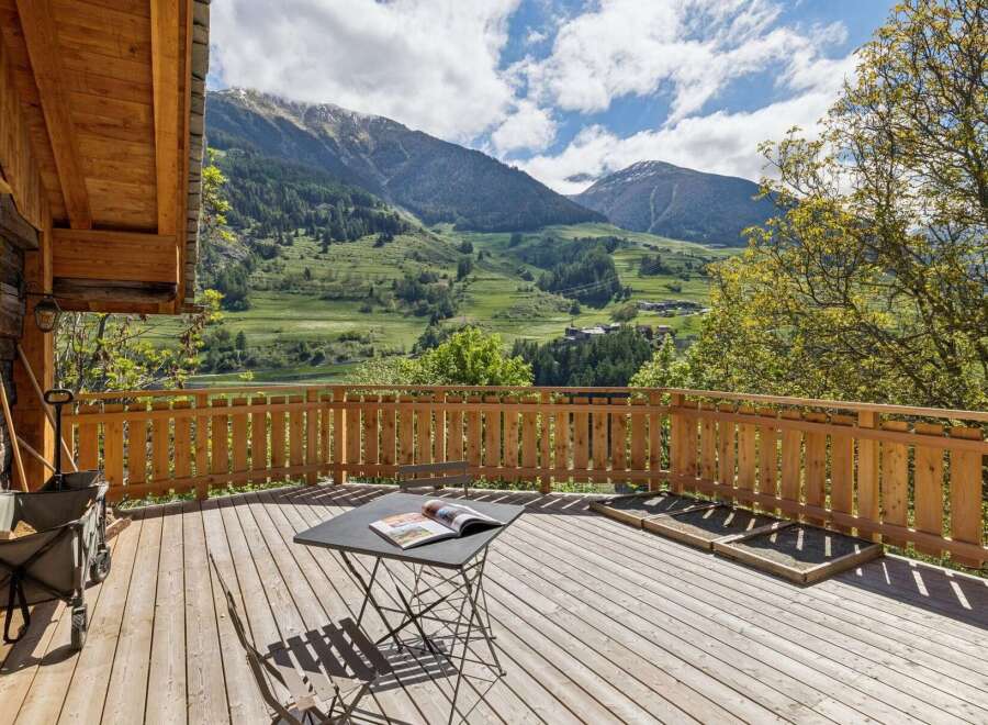 Enjoy breathtaking mountain views from this charming wooden deck, perfect for relaxing or entertaining.