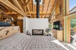 Experience rustic charm and modern comfort in this stunning bedroom featuring a cozy fireplace and a luxurious wooden-beamed ceiling.