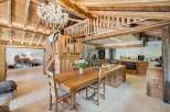 Experience rustic charm in this stunning open-plan living space, featuring a grand wooden dining table and a modern kitchen island.