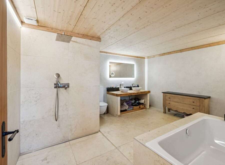 Experience luxury in this stunning bathroom featuring a spacious walk-in shower with a rainfall showerhead and a separate deep soaking tub.