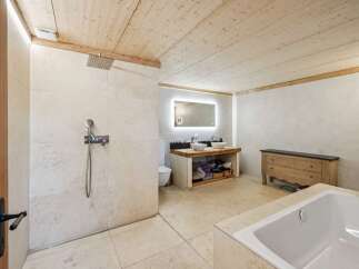 Experience luxury in this stunning bathroom featuring a spacious walk-in shower with a rainfall showerhead and a separate deep soaking tub.