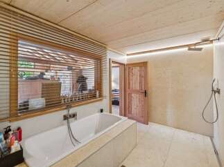 Experience ultimate relaxation in this luxurious bathroom featuring a deep soaking tub and a spacious walk-in shower.