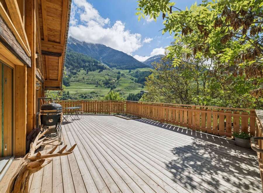 Enjoy breathtaking mountain views from this expansive wooden deck, perfect for outdoor entertaining.