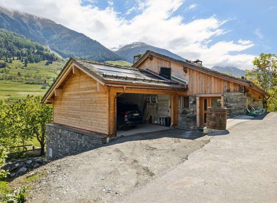Experience alpine living in this stunning wooden chalet, nestled against a backdrop of majestic mountains.