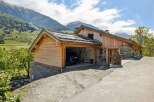 Experience alpine living in this stunning wooden chalet, nestled against a backdrop of majestic mountains.