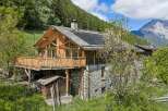Experience rustic charm in this stunning wooden and stone mountain chalet, featuring a spacious wooden deck perfect for enjoying breathtaking alpine views.
