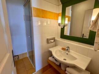 This charming bathroom features a spacious sink with a modern faucet, complemented by a wall-mounted tissue dispenser for convenience.