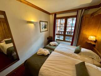 Experience cozy comfort in this charming hotel room, featuring two inviting beds perfect for a restful stay.