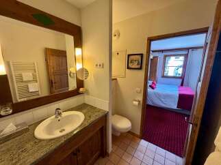 Experience comfort and convenience in this well-appointed hotel room, featuring a spacious bathroom with a granite-top vanity and a modern sink.