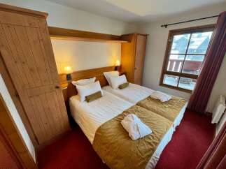 Experience cozy comfort in this charming hotel room featuring two twin beds, perfect for solo travelers or friends.