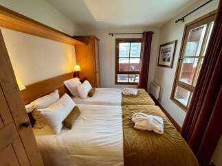 Experience comfort and style in this charming hotel room, featuring two cozy beds perfect for a restful night's sleep.