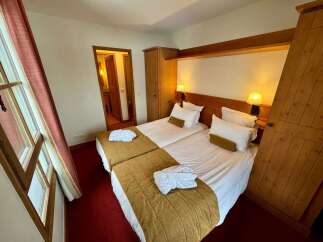 Experience comfort and style in this charming hotel room, featuring two cozy beds perfect for a restful night's sleep.