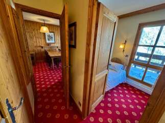 Step into this charming property featuring a cozy dining area with wooden paneled walls and a rustic wooden table, perfect for family meals.