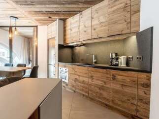 Experience modern alpine living in this stunning kitchen, featuring rustic wood cabinetry and sleek countertops.