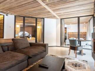 Experience modern alpine living in this stunning property featuring a spacious living area with a comfortable sectional sofa and a sleek coffee table.