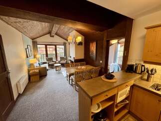 Experience cozy living in this charming apartment, featuring a spacious living area with comfortable seating and a dining space perfect for family meals.