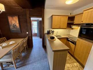 Experience cozy living in this charming apartment featuring a rustic dining area with a wooden table and chairs, perfect for intimate meals.