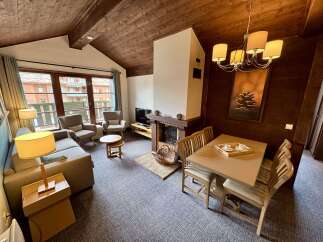 Experience cozy living in this charming apartment featuring a rustic wooden ceiling and a welcoming fireplace.