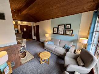 Experience cozy living in this charming room featuring a comfortable sofa and armchair, perfect for relaxation.