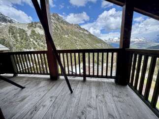 Experience breathtaking mountain views from this stunning property's expansive wooden deck.