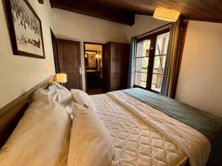 Experience cozy mountain living in this charming bedroom featuring a comfortable bed adorned with plush pillows and a textured quilt.