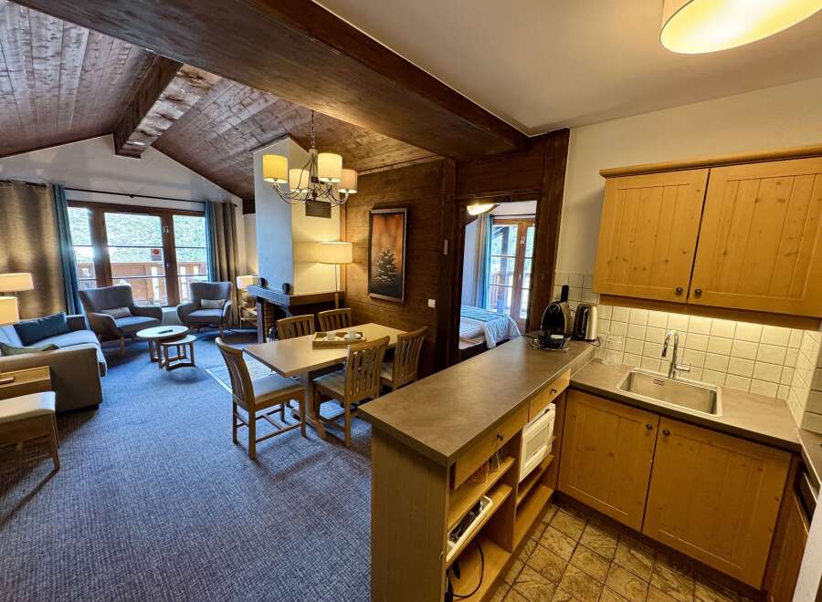 Experience cozy living in this charming mountain retreat, featuring a spacious living area with a fireplace and large windows offering scenic views.