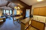 Experience cozy living in this charming mountain retreat, featuring a spacious living area with a fireplace and large windows offering scenic views.