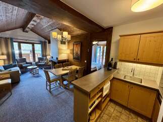 Experience cozy living in this charming mountain retreat, featuring a spacious living area with a fireplace and large windows offering scenic views.
