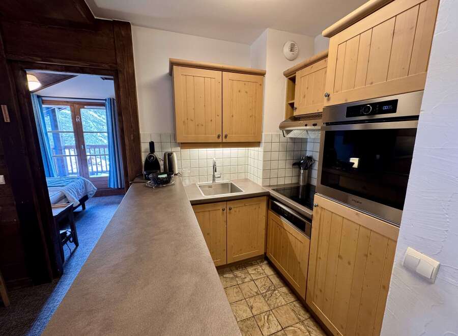Discover this charming kitchen featuring light wood cabinetry and a sleek stainless steel oven.