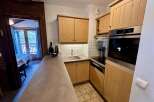Discover this charming kitchen featuring light wood cabinetry and a sleek stainless steel oven.