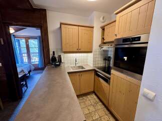 Discover this charming kitchen featuring light wood cabinetry and a sleek stainless steel oven.