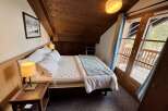 Experience cozy mountain living in this charming bedroom featuring a comfortable bed adorned with plush pillows and a soft throw.