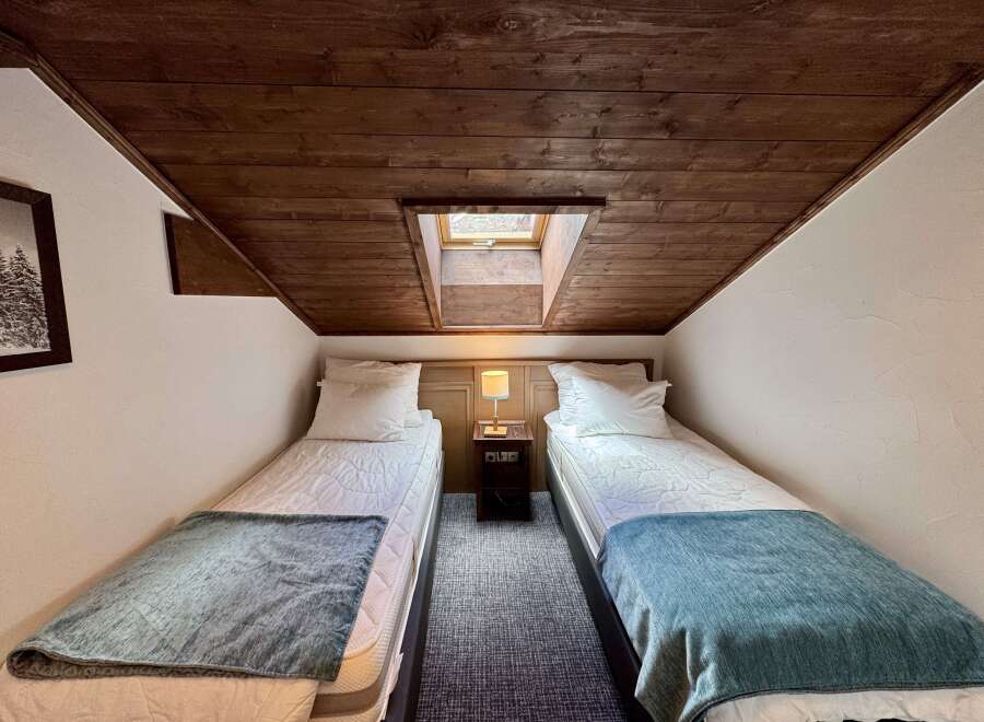 Experience cozy comfort in this charming room featuring two twin beds, perfect for families or friends.