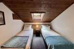 Experience cozy comfort in this charming room featuring two twin beds, perfect for families or friends.