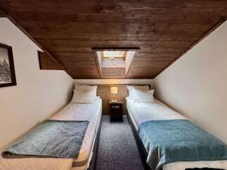 Experience cozy comfort in this charming room featuring two twin beds, perfect for families or friends.
