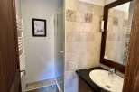 This bathroom features a spacious walk-in shower and a modern vanity with a sleek countertop and ample storage.