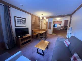 This cozy living space features a comfortable seating area with a sofa and armchair, perfect for relaxing after a day of skiing.