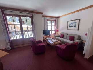 Experience cozy mountain living in this charming living room, featuring plush seating and a warm ambiance.