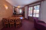 Experience cozy mountain living in this charming dining area, featuring a warm wooden table and chairs perfect for family meals.