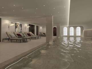 Experience ultimate relaxation in this luxurious indoor pool area, featuring comfortable chaise lounges and ambient lighting.
