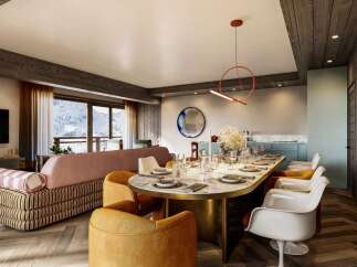 Experience luxury mountain living in this stunning dining and living area, featuring a spacious dining table set for a feast and plush seating perfect for relaxation.