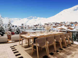 Experience luxury mountain living with this stunning chalet featuring an expansive outdoor dining area overlooking a picturesque ski village.